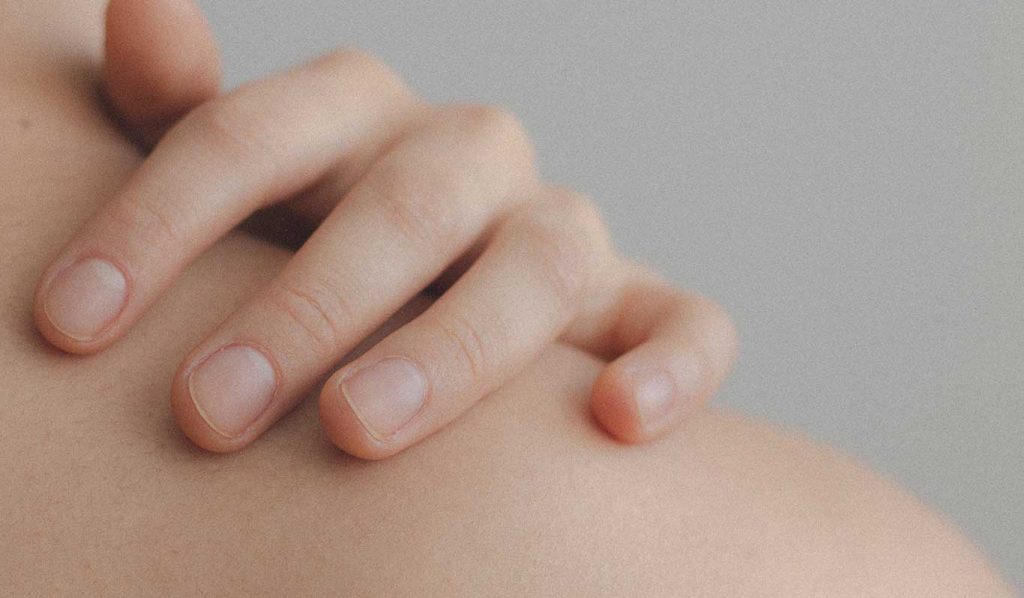 Hand berührt Haut am Nacken