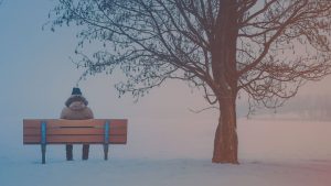 Person auf einer Bank im Winter