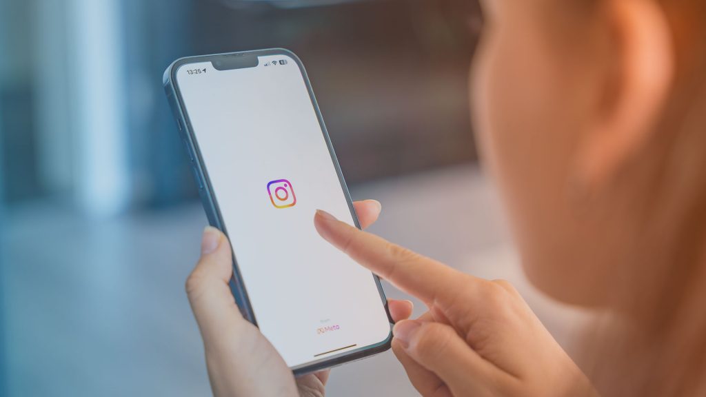 Frau mit Smartphone. Alpha1 nun auf Instagram