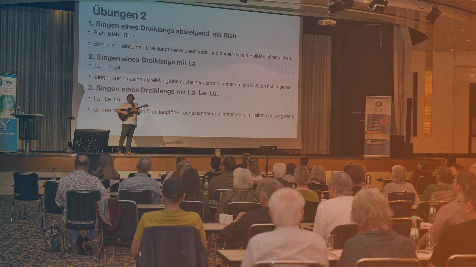Markus Baltensperger führt mit seiner Gitarre eine Gesangsübung an