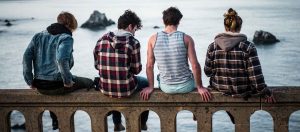 Jugendliche sitzen auf einer Brücke