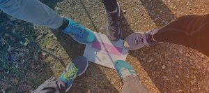 Fünf Beine die auf einem Teilnehmerschild des Rare-Diseases-Run von 2026 stehen
