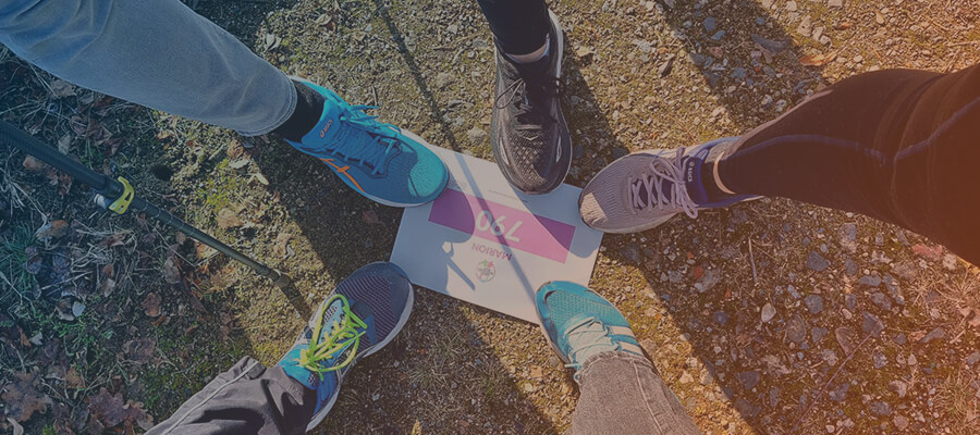 Fünf Beine die auf einem Teilnehmerschild des Rare-Diseases-Run von 2026 stehen