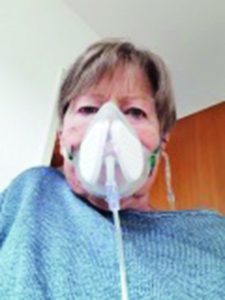 Frau mit Sauerstoff-Versorgung und Atemmaske